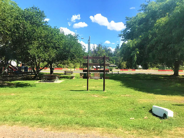 A field with picnic tables, a playground and a sign that says Brisbane Valley Rail Trail
