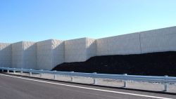 Patterned concrete panels on a roadside noise barrier.