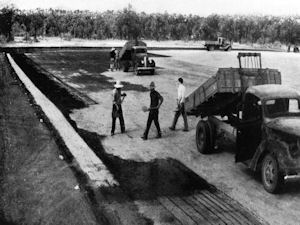 Spreading gravel on fresh bitumen at Charters Towers Aerodrome.