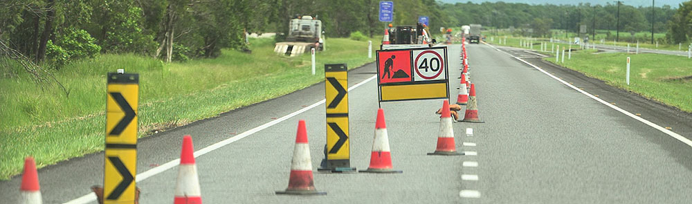 Roadworks taking place on a sealed two lane road, with a 40 KM/H speed limit sign.