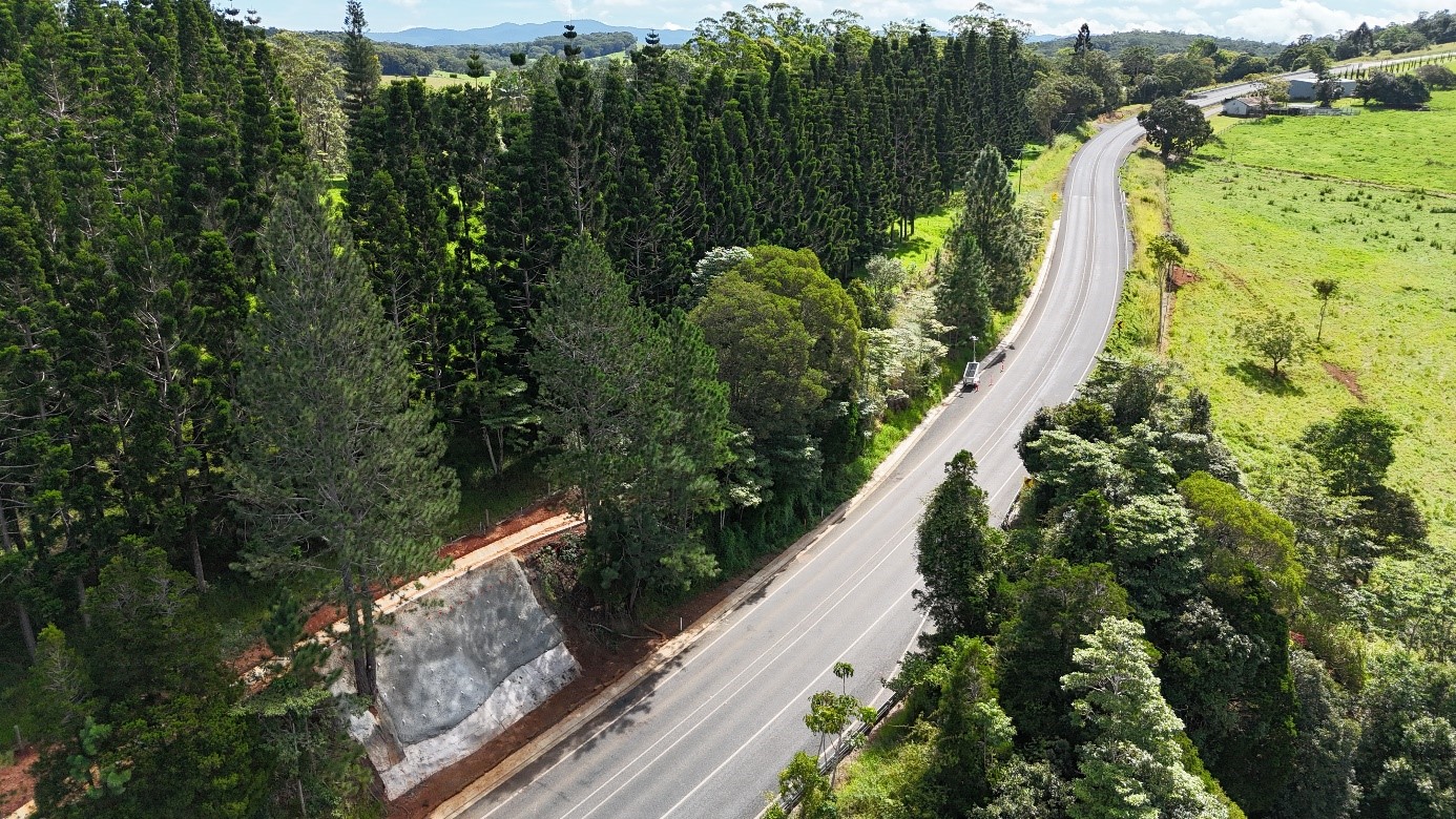 Aerial view of the completed upslope site on the Gillies Range Road. A winding road with trees on either side.