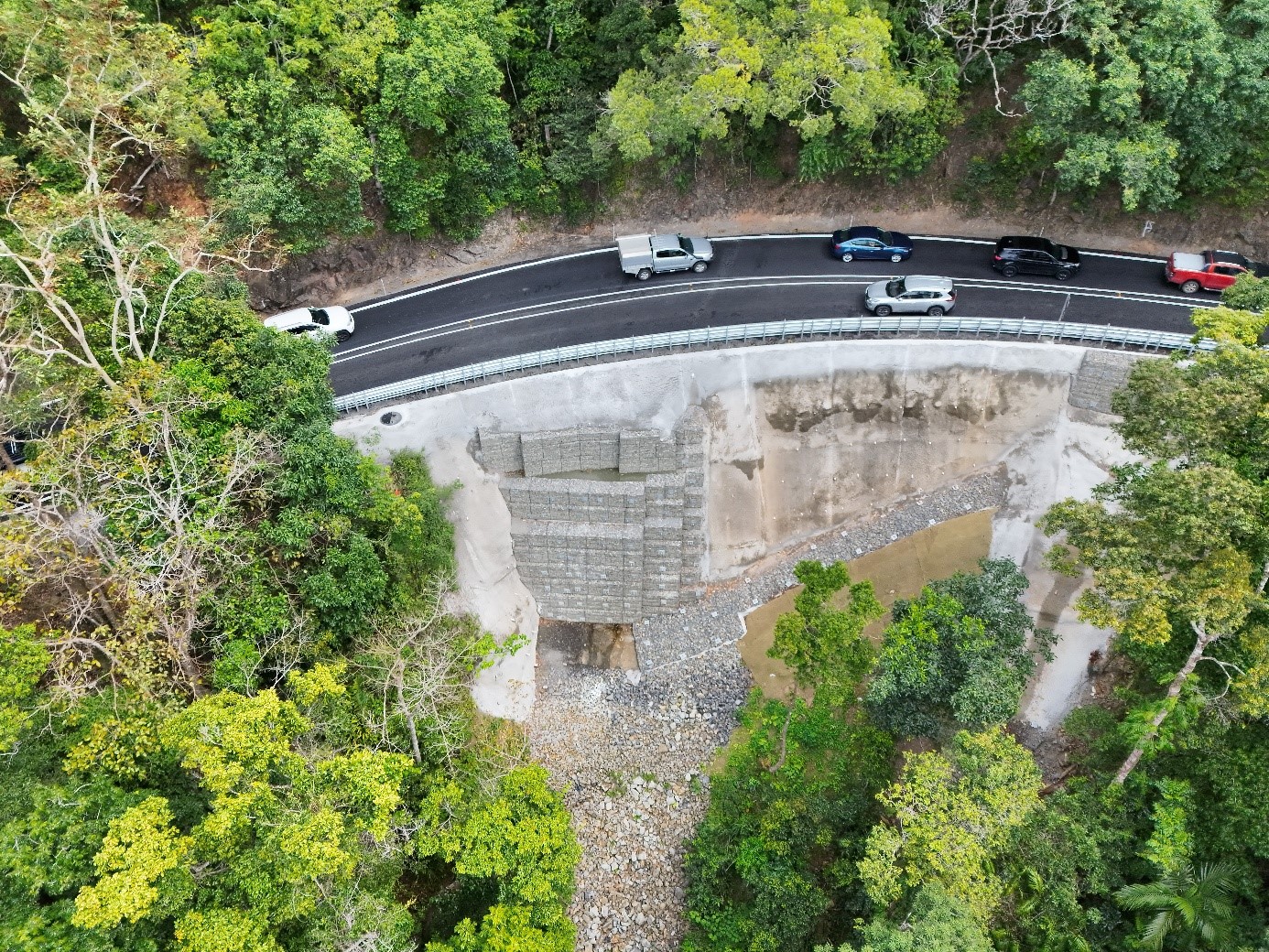 Completed downslope slip and Henry Ross Lookout. Cars on a windy road travelling in both directions with trees on the slopes on either side of the road.