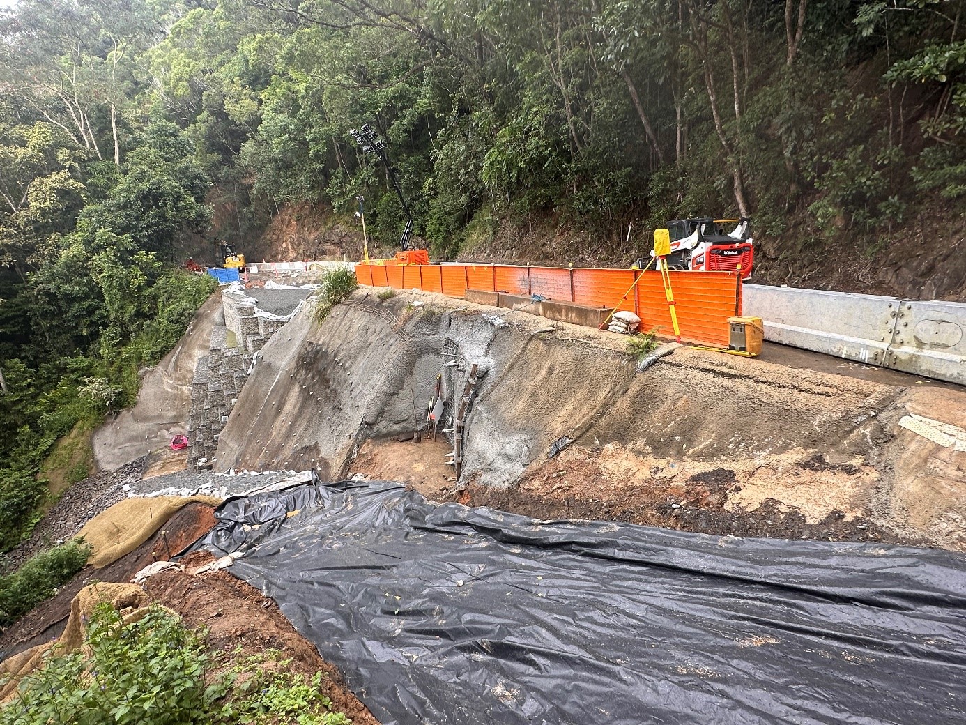 Working construction site on a side of a slop to stabilise downslope slipping from further damage caused by a natural disaster. 