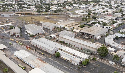 Aerial view of the Rockhampton Railyards industrial precinct, showcasing rail tracks, various structures, and the historic circular roundhouse