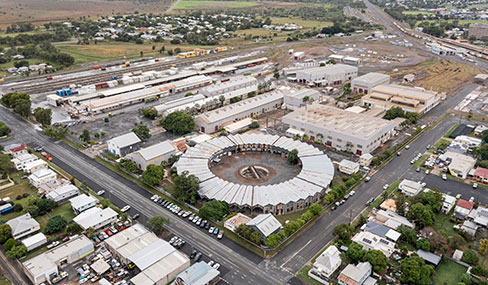 Aerial view of the Rockhampton Railyards site featuring the circular roundhouse at the centre, surrounded by old storage sheds and rail tracks.