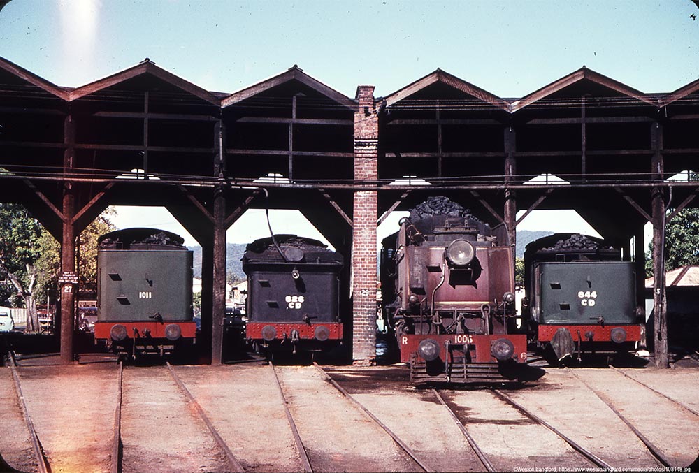 Historic image of a steam train and trailers parked in the circular roundhouse at Rockhampton Railyards 1966.