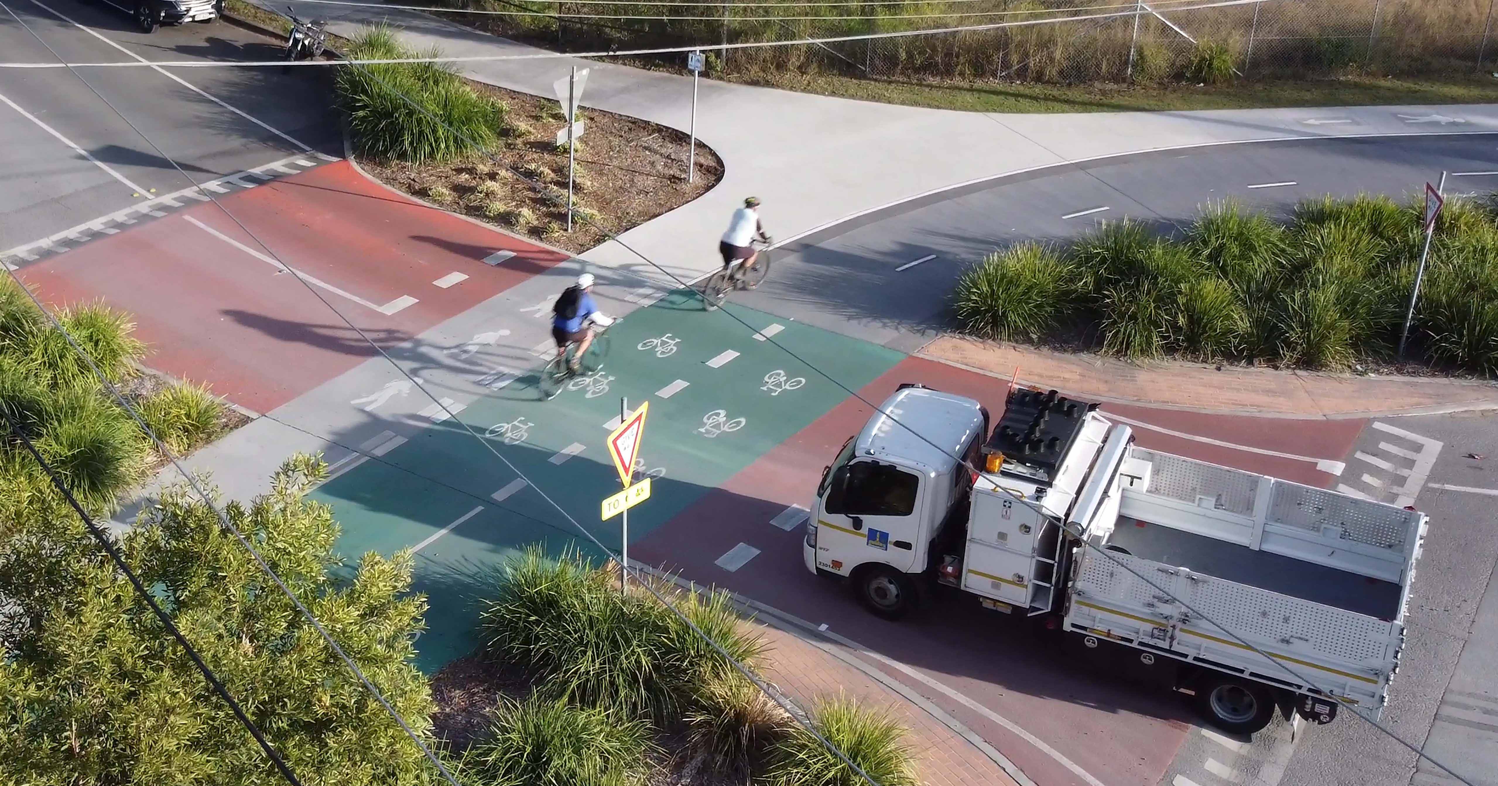 Aerial view of raised priority crossing on Somerset Street, with truck stopped at intersection giving way to 2 bike riders using the path