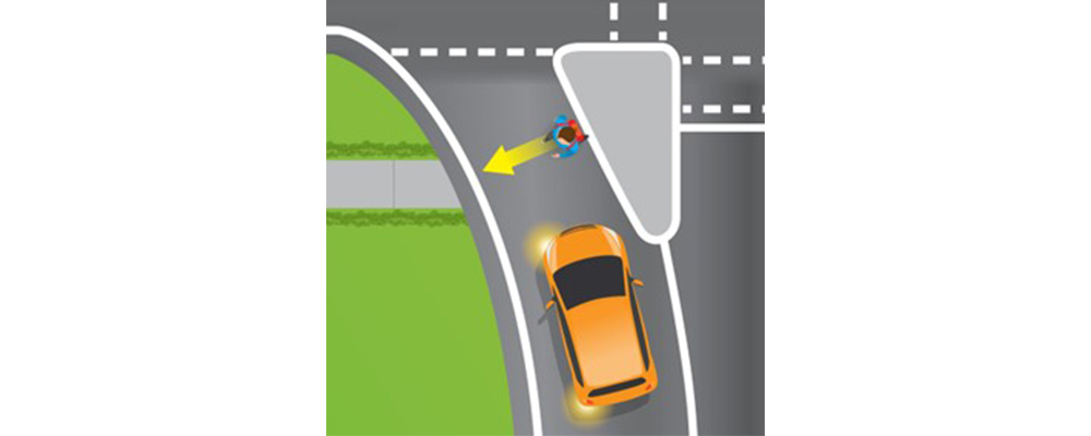 A person crossing the road while a car in the slip lane, with its left indicator flashing, stops to let them cross safely.