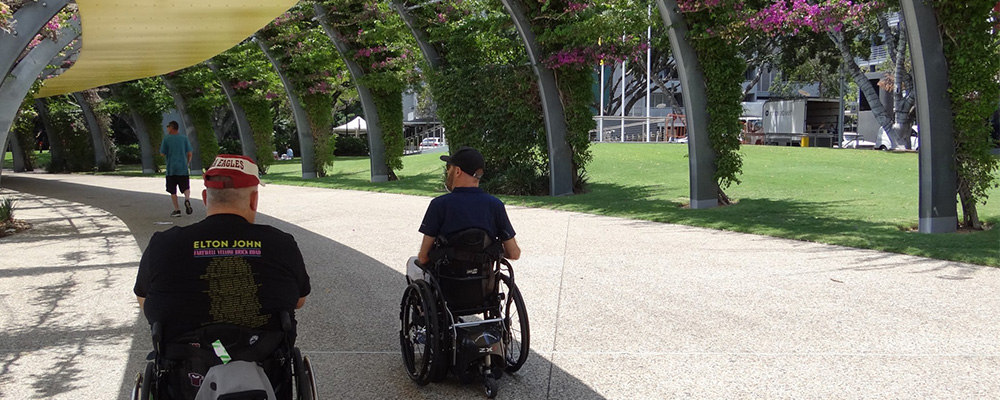 People walking and moving with the assistance of Personal Mobility Devices under a canopy in Southbank.