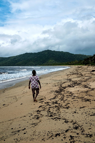 Marie walking on the beach near the water